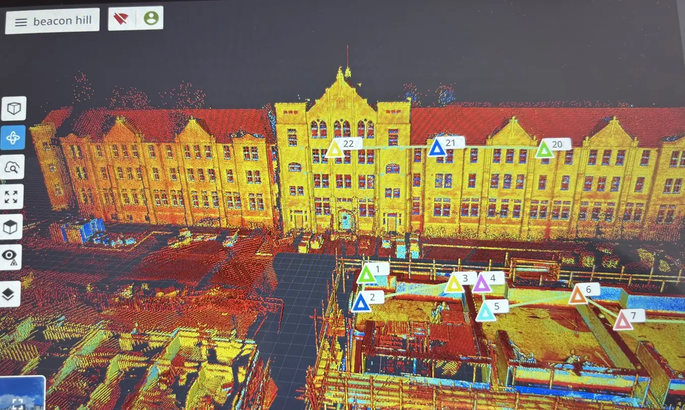 Colourised point cloud of a multi-storey brick building and adjacent construction site, captured with a Trimble X9 laser scanner
